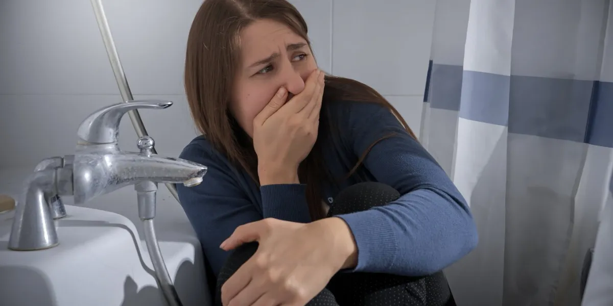 afraid woman woman hiding in bathroom from criminal and closing her mouth with hand concept of domestic violence victim, stress, danger at home, fear