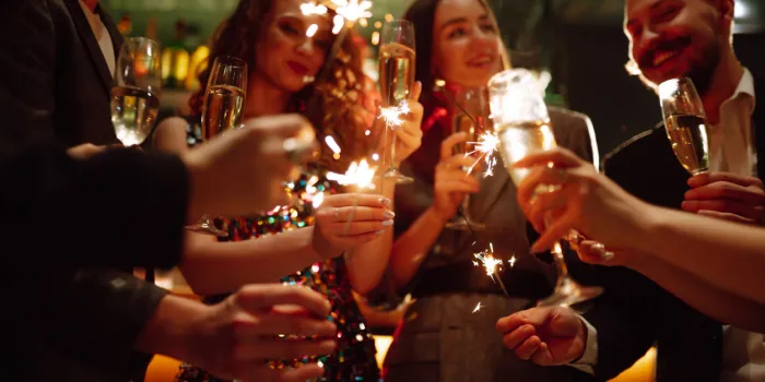sparkling sparklers in the hands playing firework to celebrate winter holidays with friends at the party magic new year, christmas