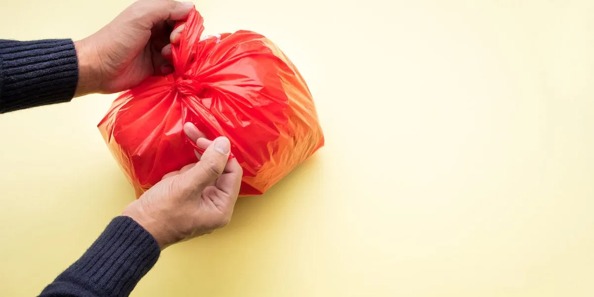 male hand packing food trash with red plastic bag on color backgroundrecycle and environment concepts ideas (male hand packing food trash with red plastic bag on color backgroundrecycle and environment concepts ideas, ascii, 109 components, 109 byte