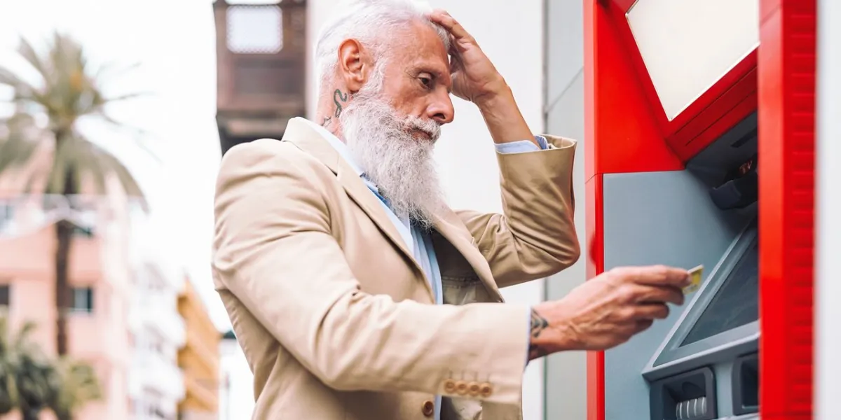 happy mature man withdraw money from bank cash machine with debit card - senior male doing payment with credit card in atm - concept of business, banking account and lifestyle people