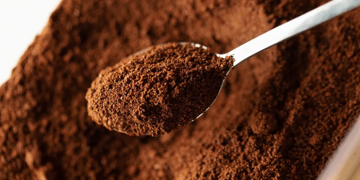 ground coffee in spoon, natural coffee background, macro