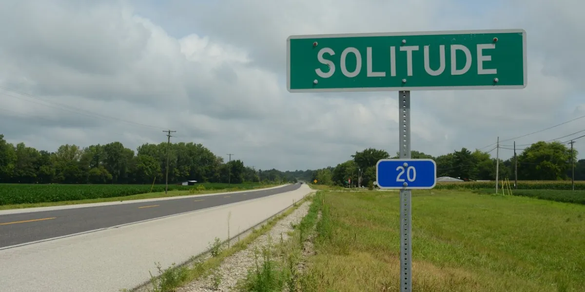road sign for small town of solitude on rural highway in indiana