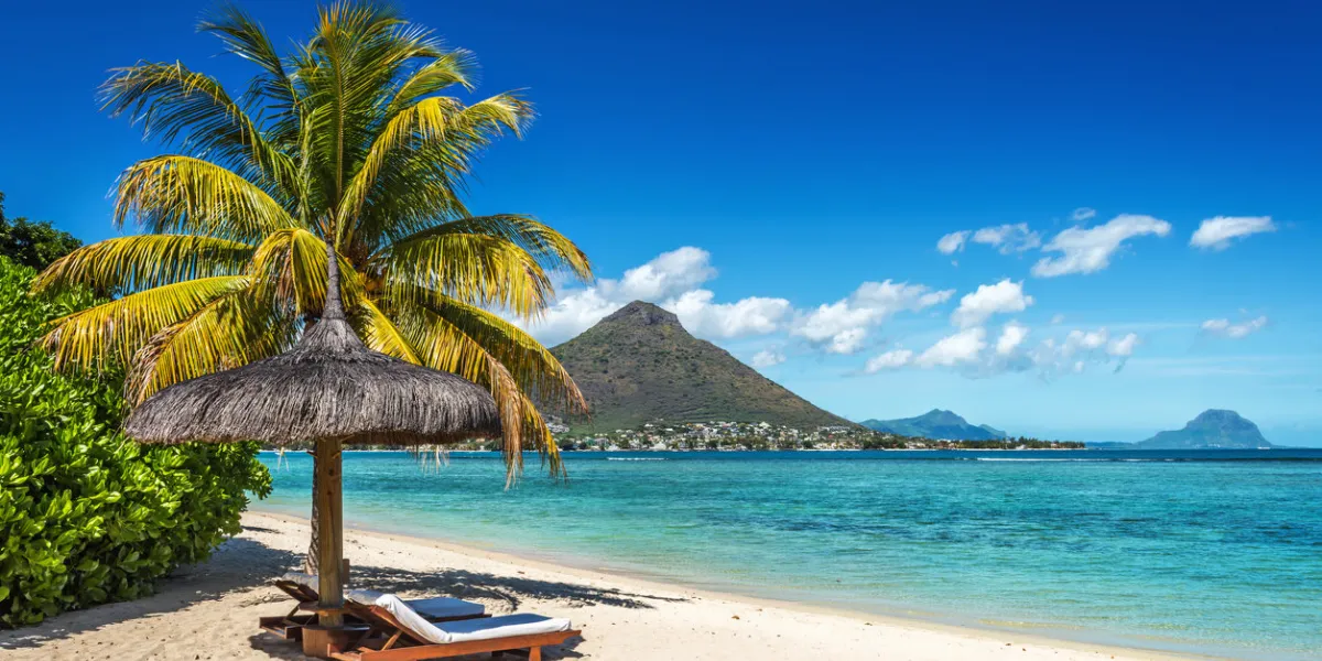loungers and umbrella on tropical beach in mauritius island, indian ocean