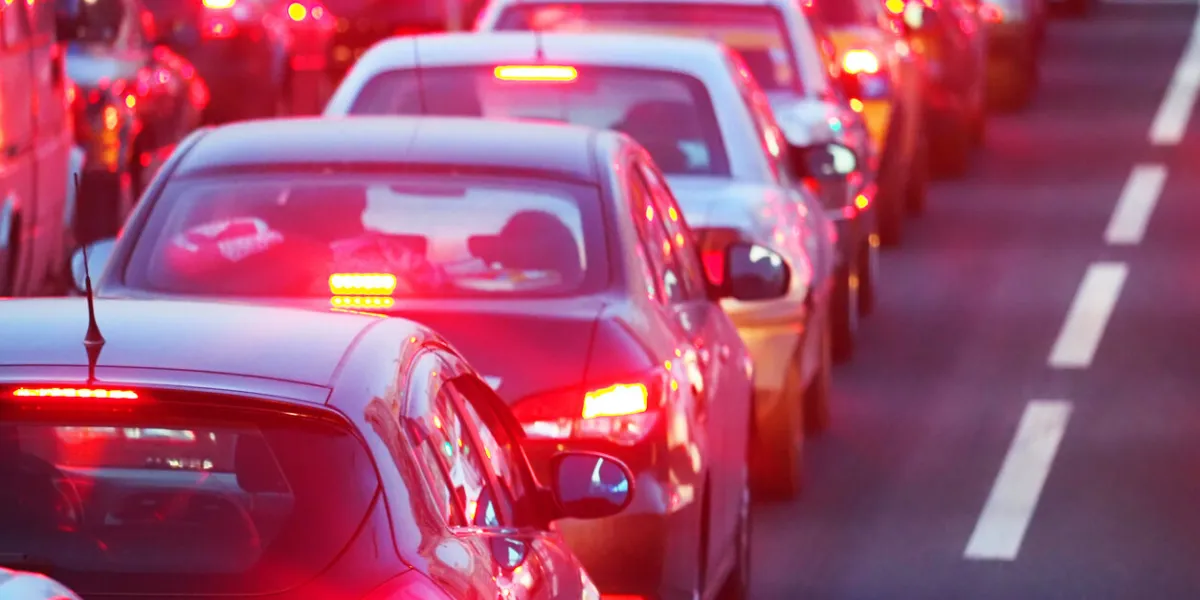 evening, city traffic jams, street road standing in a row cars, rear view, red stop lights dividing strip