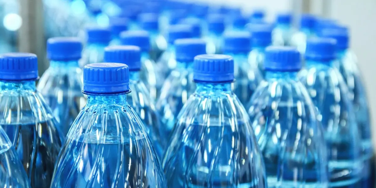closeup on mineral water green bottles in raw and lines