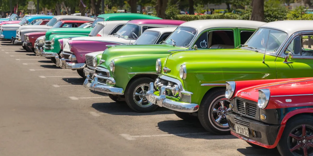 havana, cuba - july 23, 2018, a row of typical colorful cuban oldtimer classic cars standing in line during day time on a parking lot