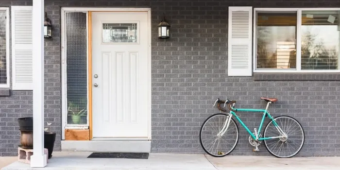 front porch of grey gray brick house with parked bike