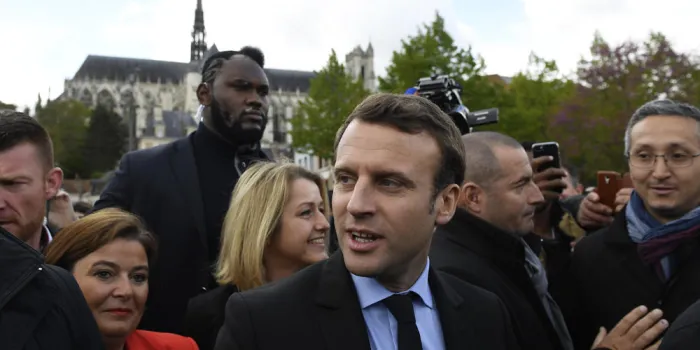 candidat à l'élection présidentielle française pour le mouvement in marche emmanuel macron se promène devant la cathédrale d'amiens le 26 avril 2017, suivi de son garde du corps surnommé makao afp photo piscine eric feferberg