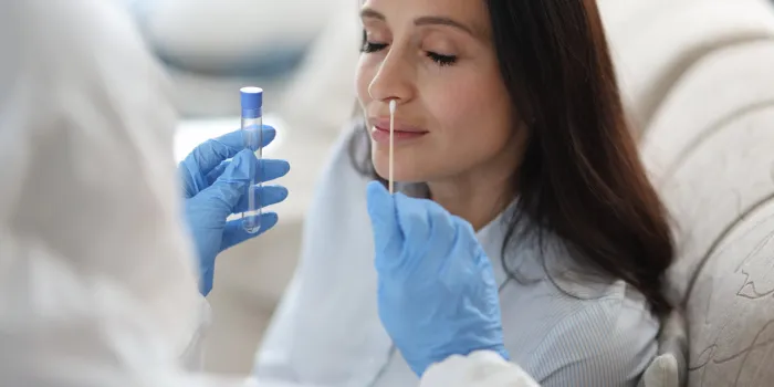 doctor laboratory assistant in protective suit takes swab from nose of sick patient at home laboratory tests for coronavirus concept