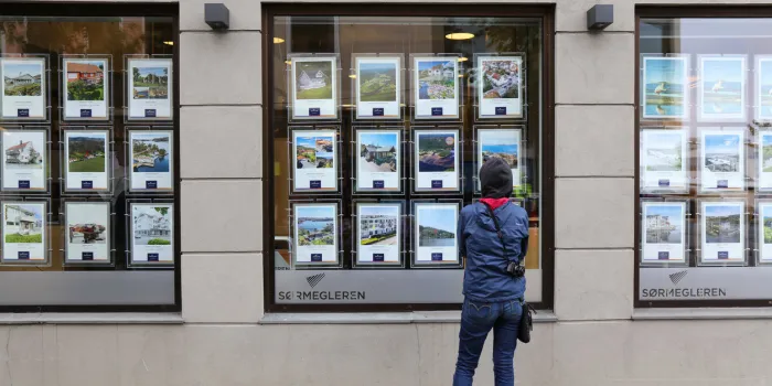 person analyzes real estate offers of a real estate agency window in town of mandal in vest-agder county of norway