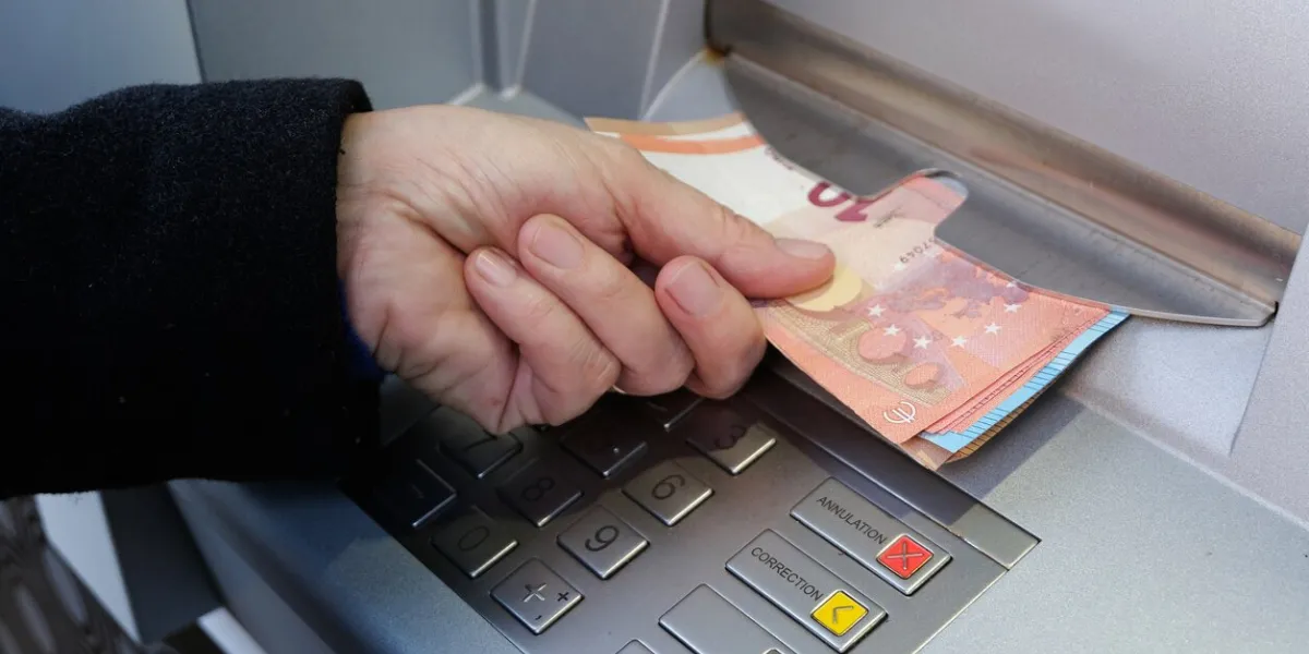 close-up of someone withdrawing euro banknotes from an atm