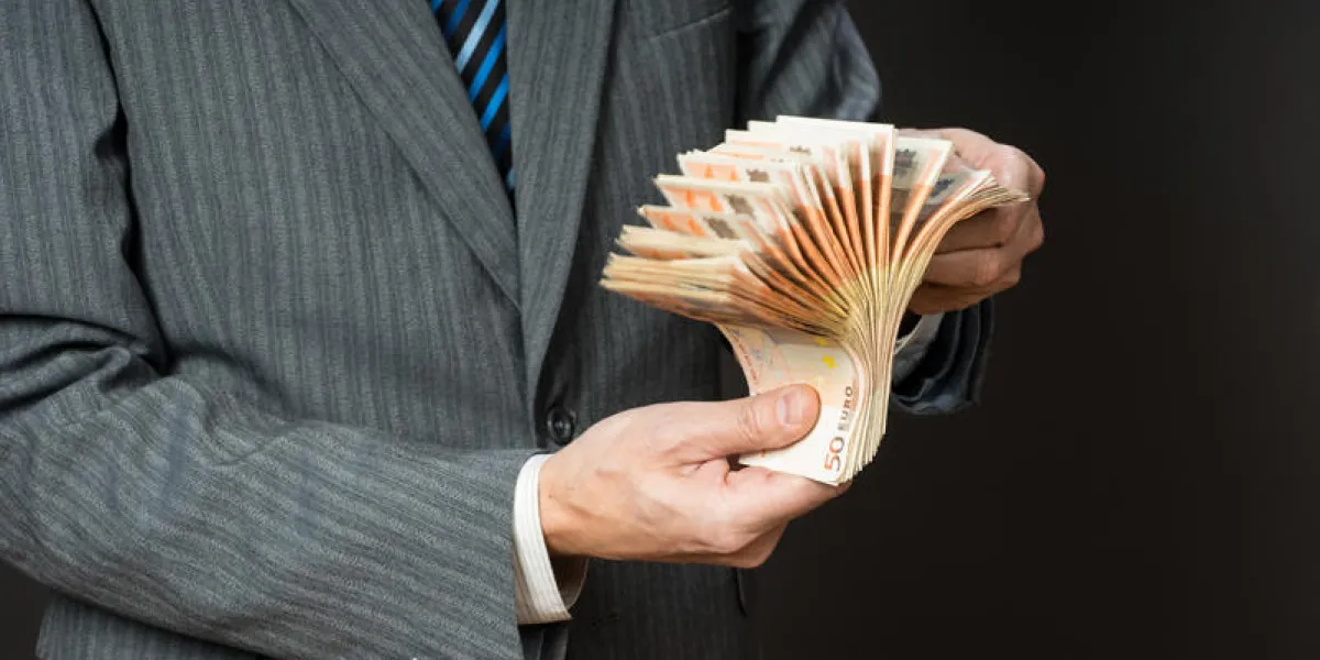 business man is holding cash, fan of fifty euros person counts money businessman hands and euro bills, isolated gray background