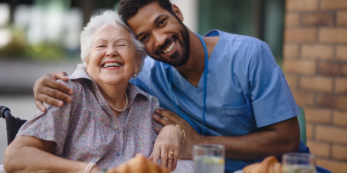caregiver having breakfast with his client at a cafe