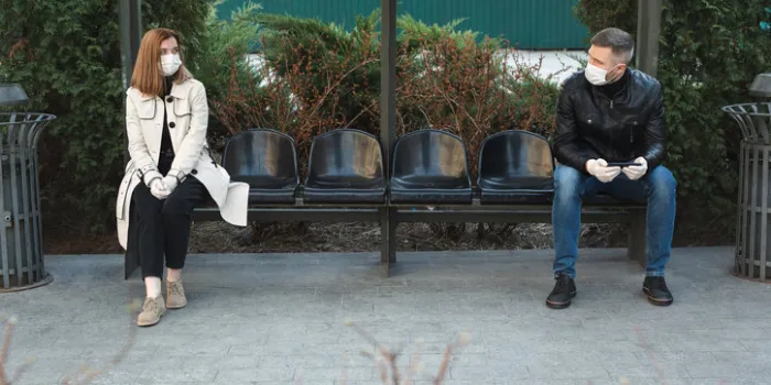 the distance between a man and a woman at a bus stop during a coronavirus epidemic covid