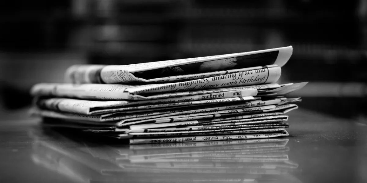 stacks of old newspapers printed on paper with news and headlines
