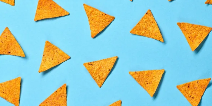 nachos mexican chips colorful pattern on blue background tortilla nacho chip closeup, fashionable trendy flat lay crisps nachos snack wallpaper, top view creative concept