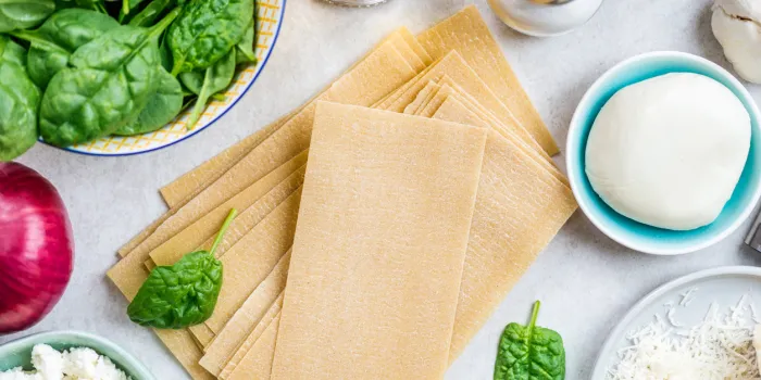 ingredients for vegetarian spinach and ricotta lasagna, top view, grey background