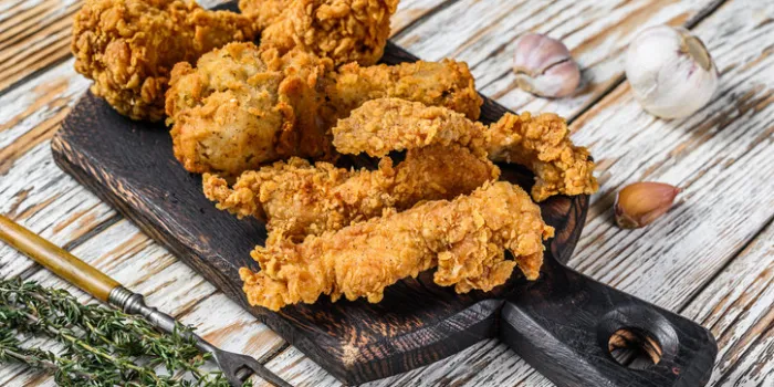 crispy chicken drumstick, leg, wing and breast strips white wooden background top view