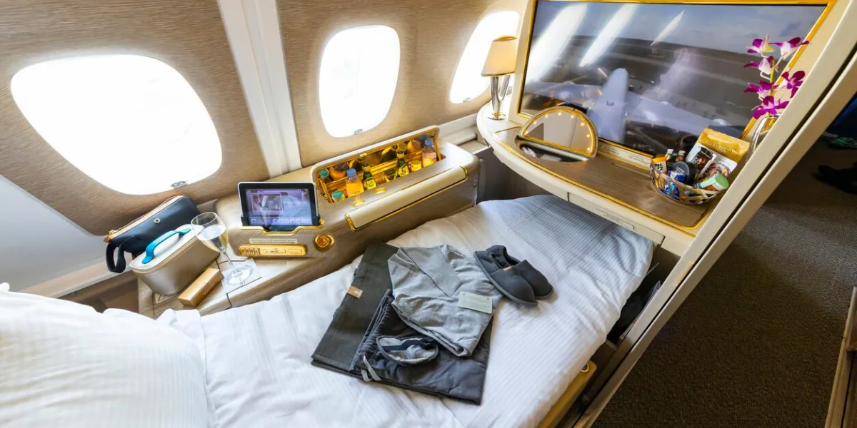 berlin, germany - june 7, 2024  luxurious travel style onboard of emirates airbus a380 in first class window seat with sleeping bed and amenity kit