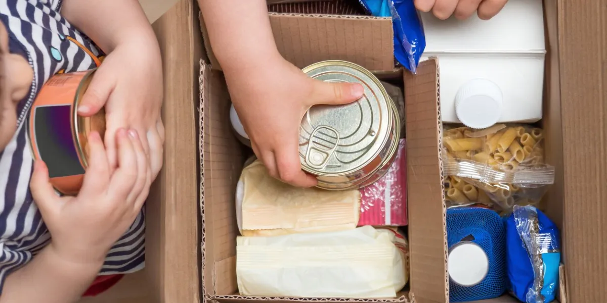 children opening a food delivery box at home, online ordering grocery store delivery box full of food in concept donation boxparcel delivery during quarantine due to coronavirus covid-19 disease