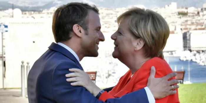 french president emmanuel macron (l) embraces german chancelor angela merkel prior to their meeting in marseille, on september 7, 2018   afp photo   christophe simon