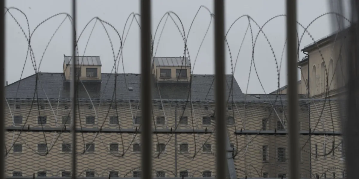 a prison window with bars and razor wire in front of it
