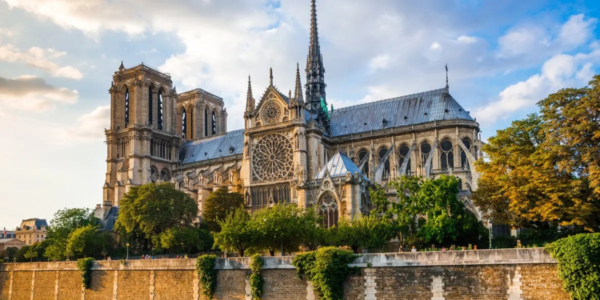 gorgeous sunset over notre dame cathedral with puffy clouds, paris, france