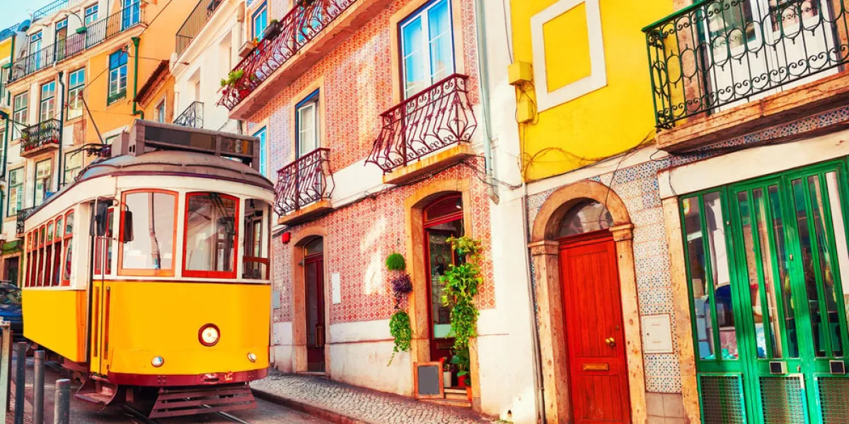 yellow vintage tram on the street in lisbon, portugal famous travel destination