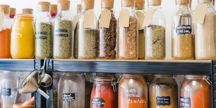 eco-friendly zero waste shop glass bottles, jars with herbs and spices in sustainable plastic-free grocery store bio organic food shopping at small local businesses new trend alternative buying