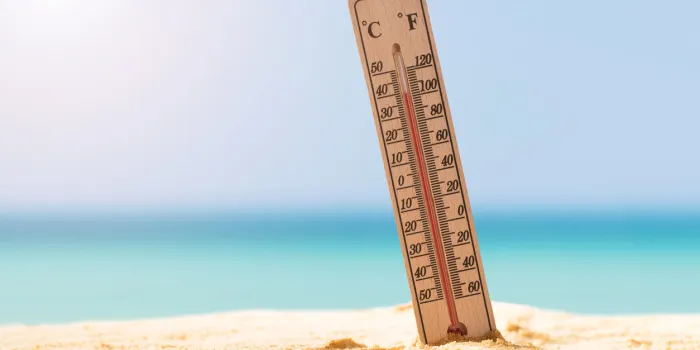 close-up of thermometer on sand showing high temperature