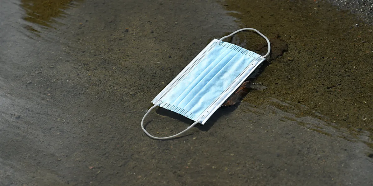 nantes, france-07 28 2021 a protective face mask thrown and abandoned in a water puddle in a street of nantes, france during the global coronavirus epidemic