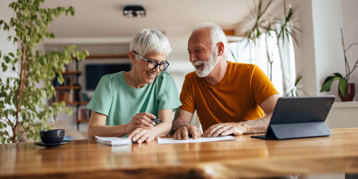 mature husband, helping his wife with their business, at home office