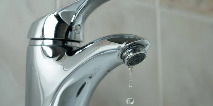 water drop dripping from the tap and water shortage