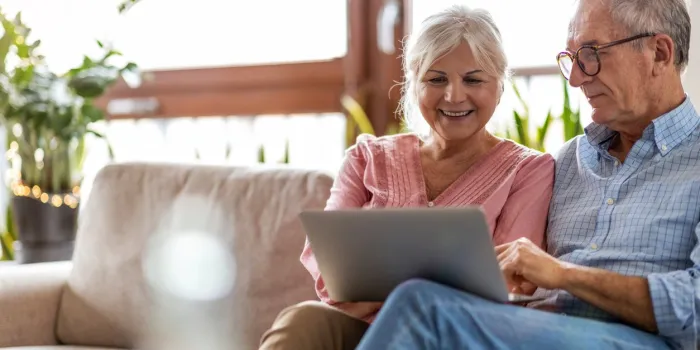 mature couple using a laptop while relaxing at home