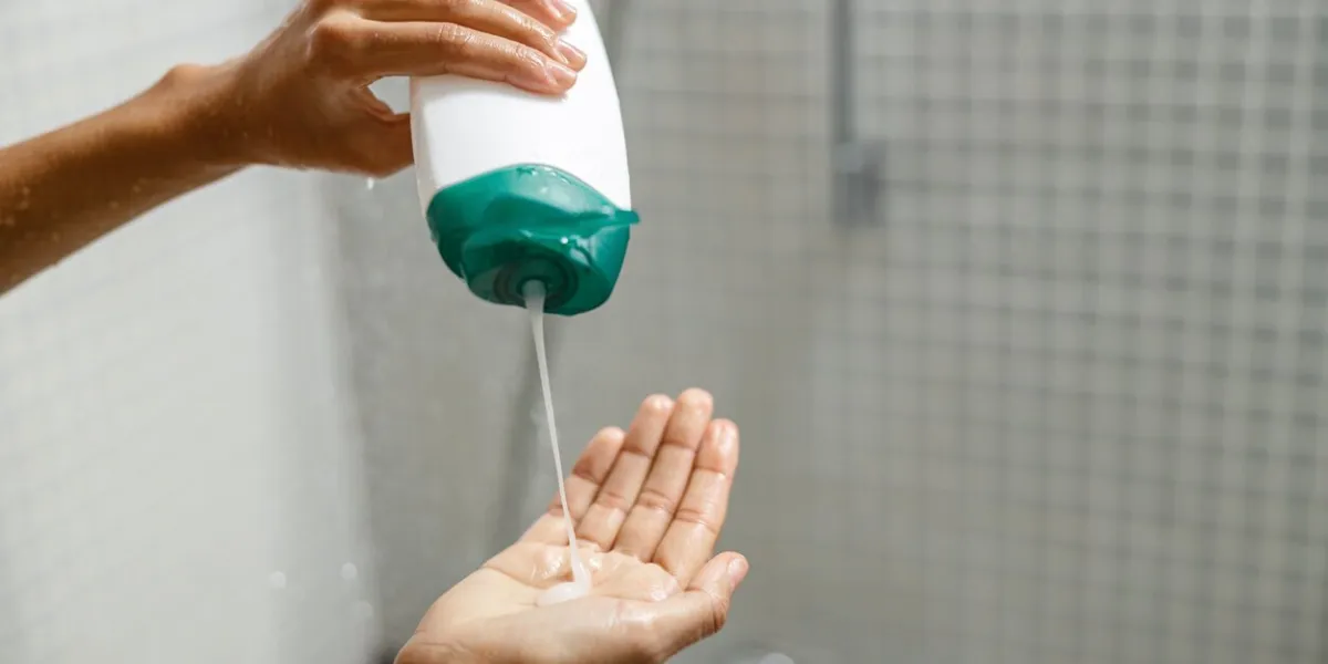 woman pouring shower gel on her hand when taking shower hygiene concept high quality photo