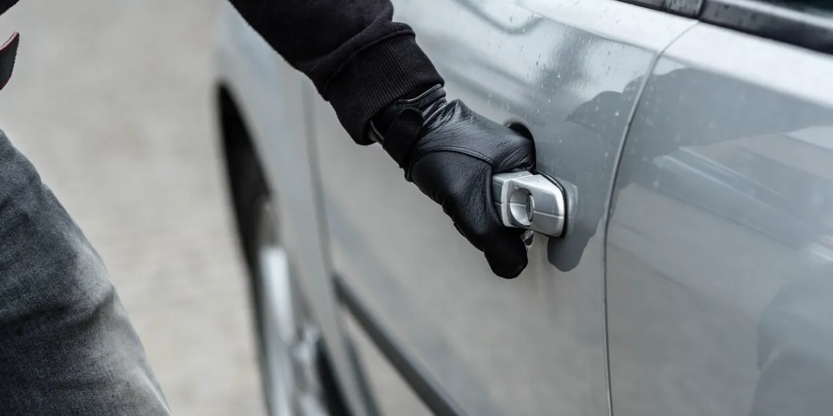 close up on car thief hand pulling the handle of a car car thief, car theft concept
