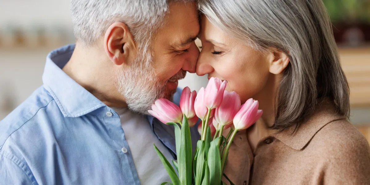 elderly couple in love hugging on valentine's day a loving senior husband gives his wife a tender bouquet of tulip flowers