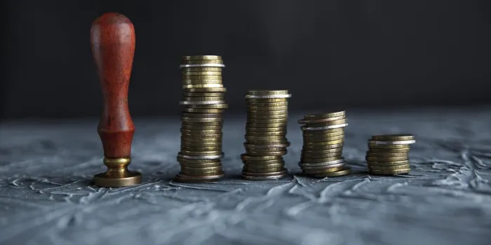 judge's hand holding gavel over stacked golden coins
