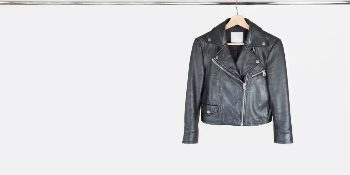 fashion leather jacket hanging on hanger on white background