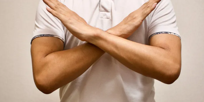 man in white t-shirt made x sign shape mean to say no