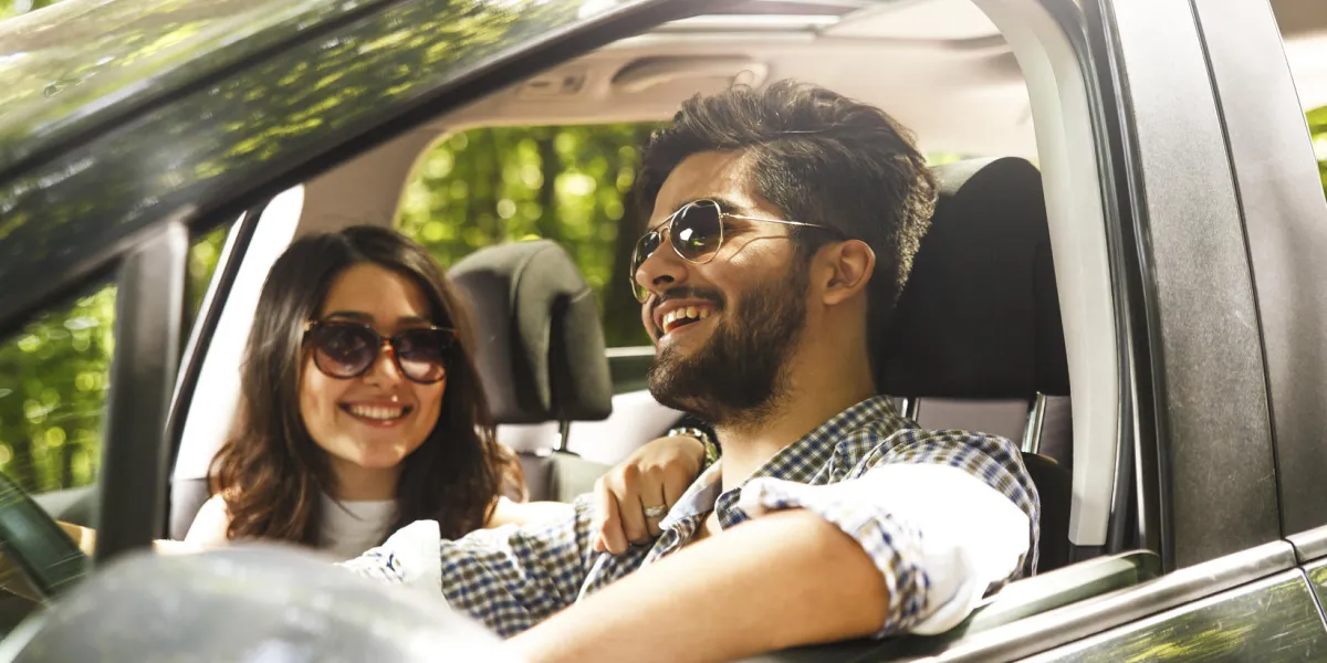 portrait de jeune couple au volant d'une voiture