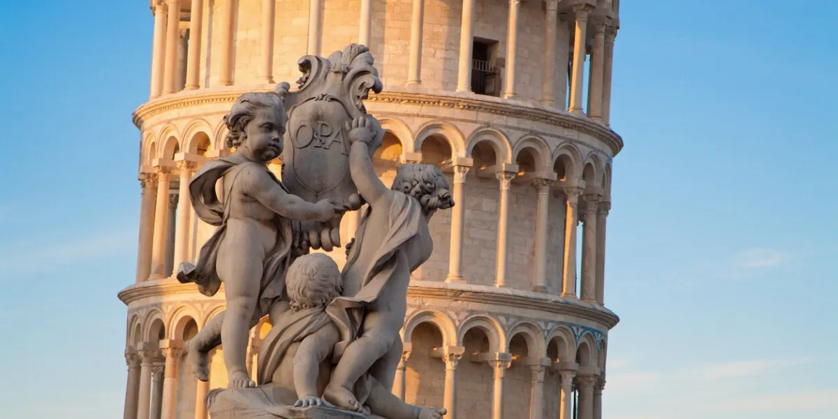 pisa - the angles sculpture and hanging tower in evening light