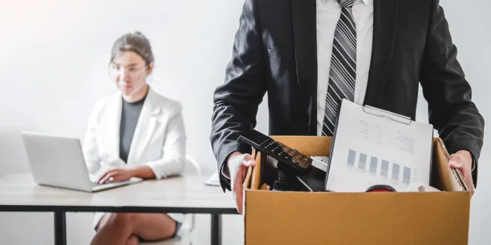 business man stressing with resignation letter for quit a job packing the box and leaving the office , resignation concept