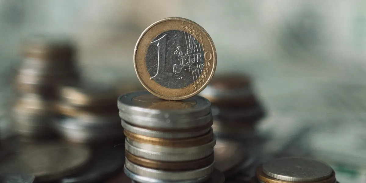 a stack of euro coins and a background of coins of different denominations