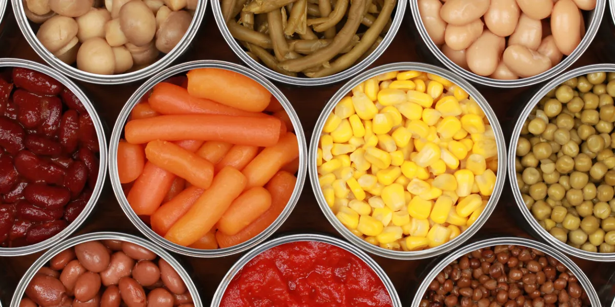 different kinds of vegetables such as corn, peas and tomatoes in cans