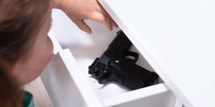 close-up girl found pistol in drawer at home