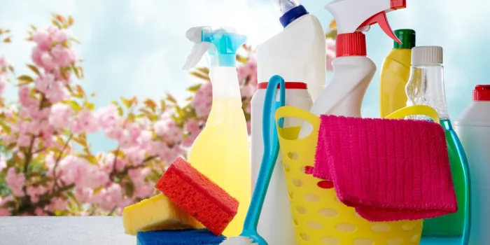 basket with cleaning products on blurry spring background cleaning with supplies, cleaning service concept copy space