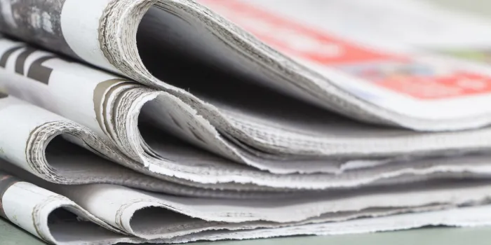pile of folded french newspapers on a table