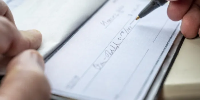 closeup of a man writing a check