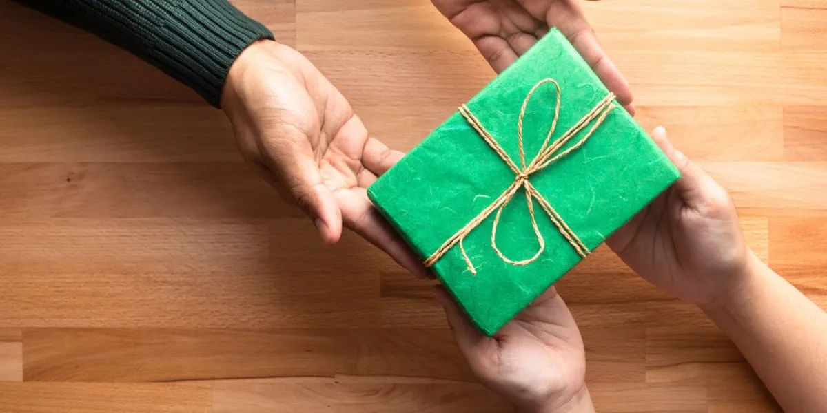 male gives a gift present to female with wooden copy space backgroundhappiness moment concepts ideas